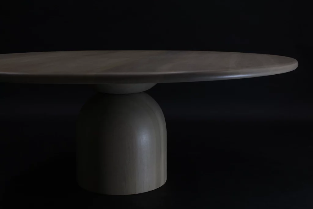 A wooden conference table in a dark photos studio setting.