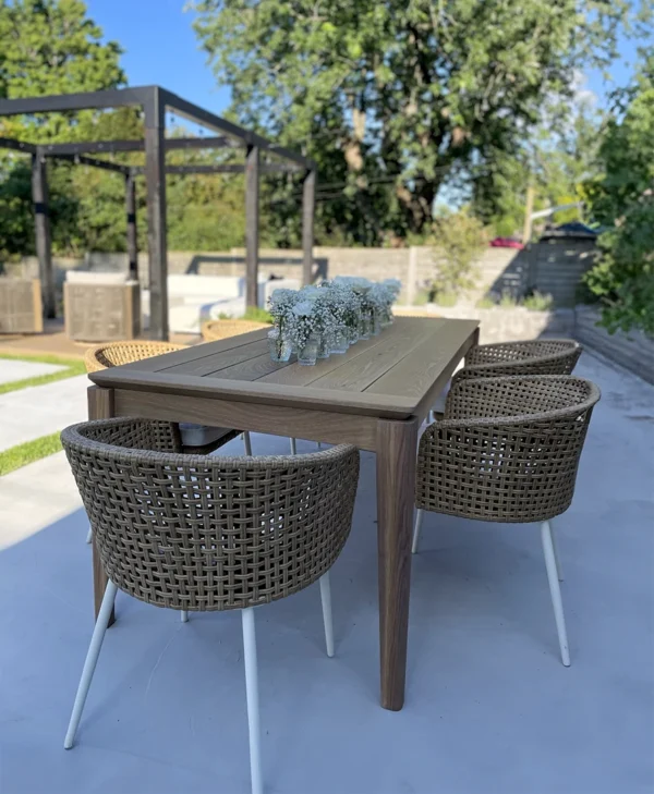A wooden dining table outdoors with chairs