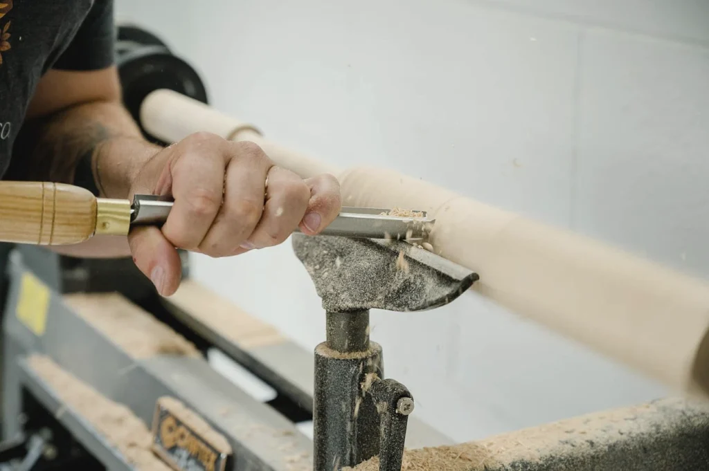 a craftsperson using a chisel to craft custom furniture